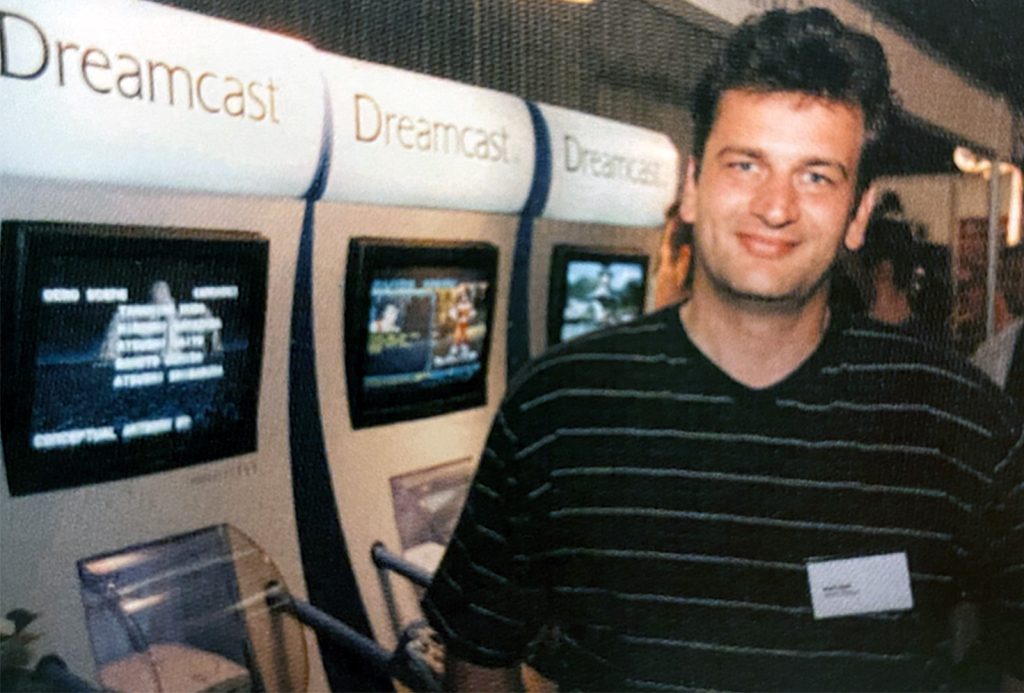 Gerard Schepper van Atoll Soft met een aantal Dreamcast demo-units op de M3 beurs. Bron: ‘M3 beleeft zeer geslaagde eerste editie’. MultiMediaMarkt, vol. 4, nr. 21, 7 oktober 1999, pp. 10–13.
